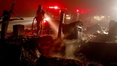 Un bombero echa agua en&nbsp;Red Wine Road, en Geyserville.