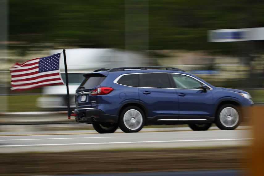 Fotografía de archivo del 28 de mayo de 2021 de un conductor de Massachusetts ondeando una bandera estadounidense mientras recorre la Maine Turnpike en Kennebunk, Maine.