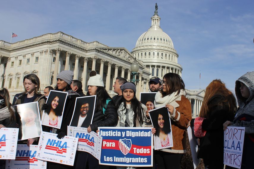 Varios jóvenes sostienen pancartas que reivindican Justicia y dignidad para todos los inmigrantes frente al Capitolio nacional en Washington.