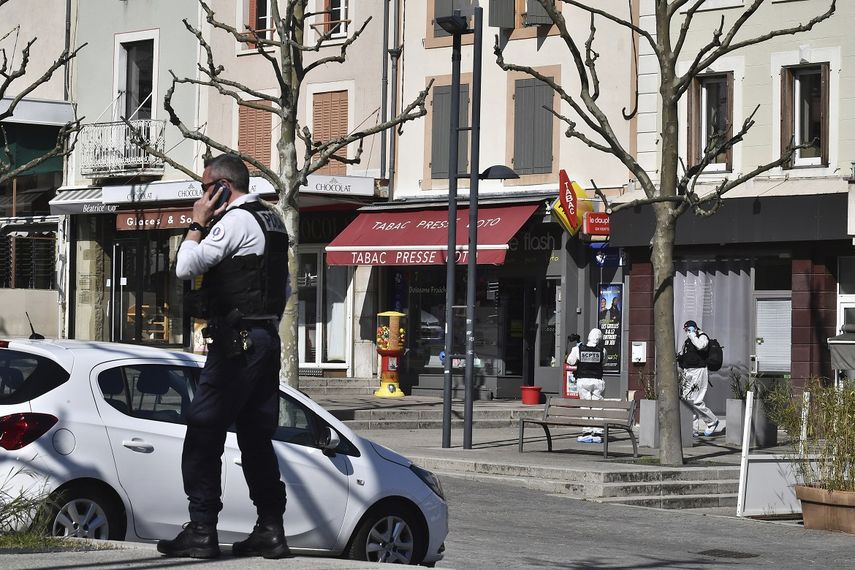 Un polic&iacute;a llama por celular despu&eacute;s de que un hombre con un cuchillo atacara a residentes que salieron de compras en una poblaci&oacute;n sometida a cuarentena el s&aacute;bado 4 de abril de 2020 en Romans-sur-Isere, en el sur de Francia.