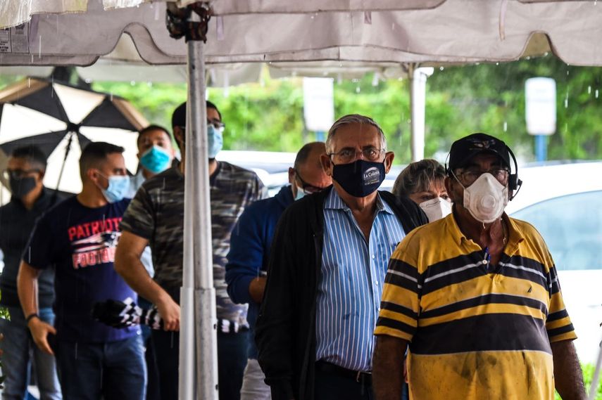 Votantes esperan en fila para emitir su voto durante la votación anticipada en el Departamento de Elecciones del Condado de Miami-Dade en Miami, Florida, el 21 de octubre de 2020.