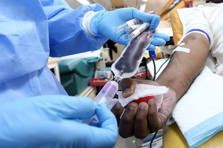 Enfermera extrae sangre a paciente.