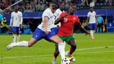 El francés Kylian Mbappé, de Francia, patea el balón mientras lo defiende el portugués Nuno Mendes en el duelo de cuartos de final de la Eurocopa, el viernes 5 de julio del 2024.