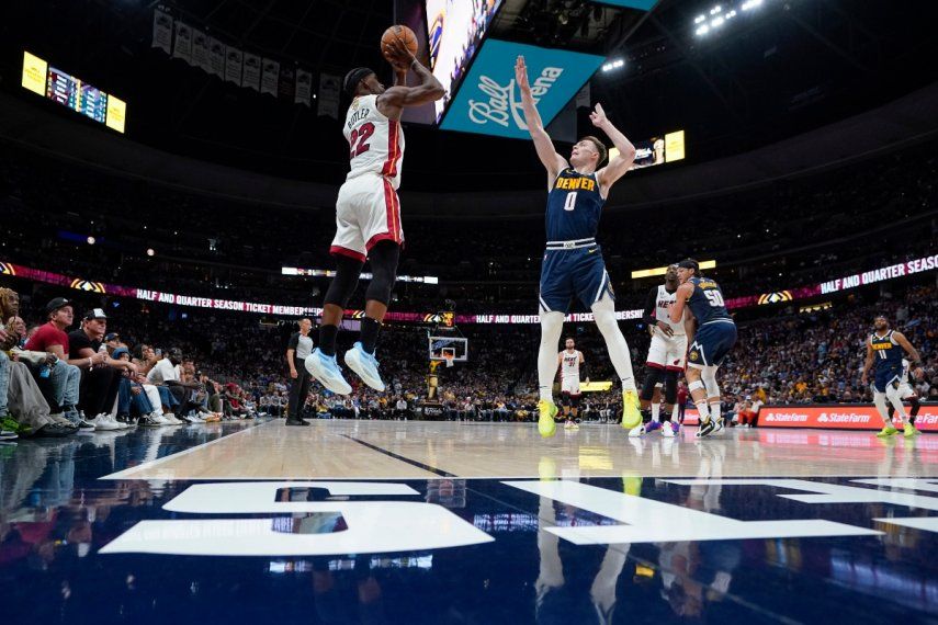 El alero del Heat de Miami, Jimmy Butler (22), dispara una canasta de tres puntos sobre el base de los Denver Nuggets, Christian Braun (0), durante la segunda mitad del Juego 2 de las Finales de baloncesto de la NBA, el domingo 4 de junio de 2023 en Denver.&nbsp;