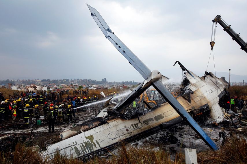 Los bomberos trabajan entre los restos del avión que se estrelló en el aeropuerto de Katmandú (Nepal) .&nbsp;