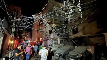 La gente se reúne cerca de un edificio destruido por un ataque aéreo israelí en el sur de Beirut, Líbano, el martes 30 de julio de 2024, en respuesta al ataque perpetrado por Hezbolá a territorio israelí que dejó 12 muertos.