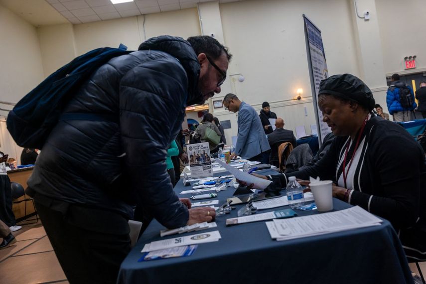 Un hombre busca opciones en una feria de empleo.