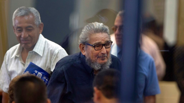 Abimael Guzman, fundador y líder del movimiento guerrillero Sendero Luminoso (al centro), mientras ingresa a la sala de un tribunal en la Base Naval de Callao, Perú.