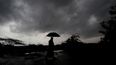 Una persona sostiene un paraguas mientras las nubes oscuras se ciernen sobre el distrito de Balasore en Odisha, India, el martes 25 de mayo de 2021, antes de que una poderosa tormenta se dirija hacia la costa oriental.&nbsp;