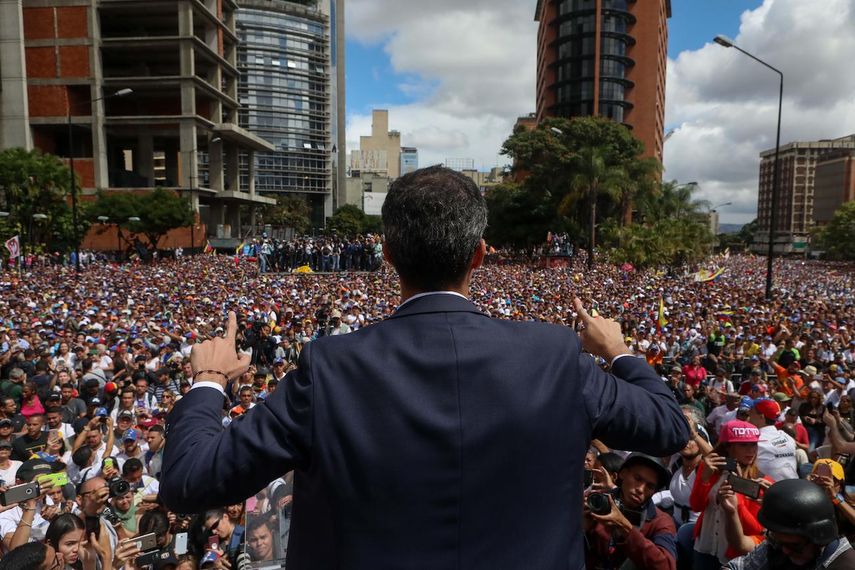 El presidente del Parlamento venezolano, Juan Guaidó, saluda a manifestantes tras anunciar que asume las competencias del Ejecutivo, en Caracas.
