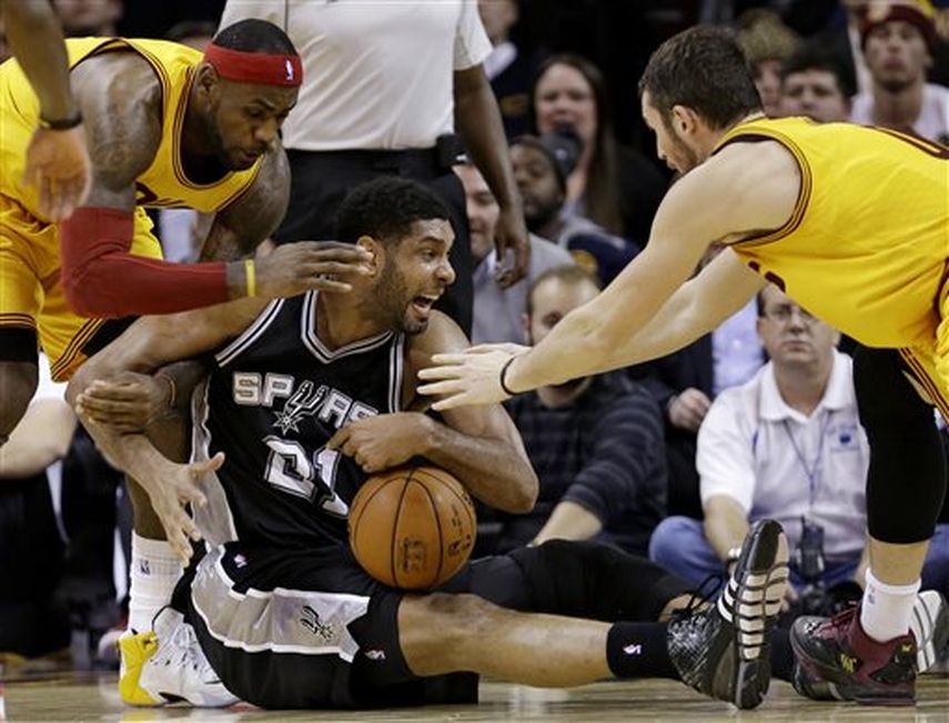 LeBron James (izq) y Kevin Love tratan de arrebatarle el balón a Tim Duncan al final del cotejo. (AP)