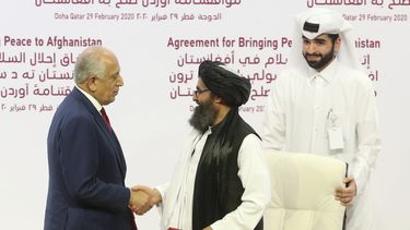 El enviado estadounidense Zalmay Khalilzad, izquierda, y el jefe político del Talibán, mulá Abdul Ghani Baradar, se estrechan la mano después de firmar el acuerdo de paz entre el Talibán y Estados Unidos en Doha, Qatar, sábado 29 de febrero de 2020.&nbsp;