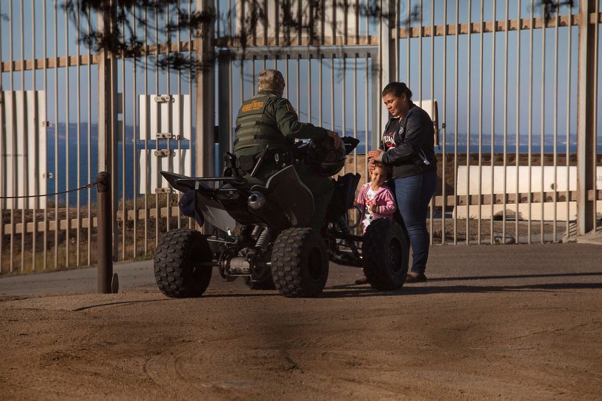 Una mujer centroamericana es detenida por un oficial en la frontera entre EEUU y Mexico.&nbsp;