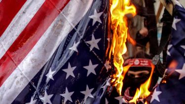 Milicianos palestinos queman una bandera estadounidense durante una protesta en&nbsp;Gaza&nbsp;(Palestina).