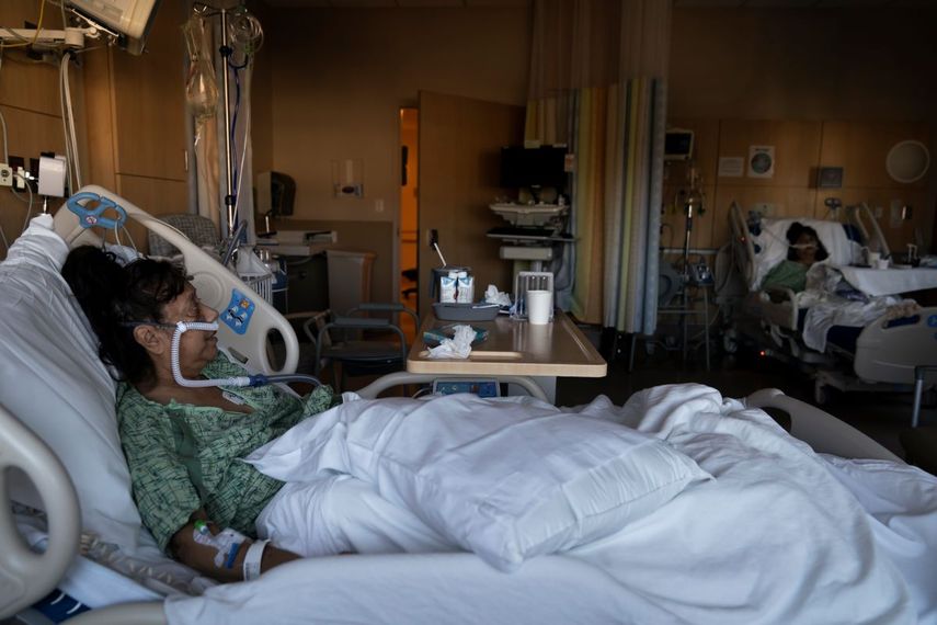 Natalie Balli, de 71 años, y su hermana gemela, Linda Calderon, al fondo, son vistas en sus camas en la unidad de COVID-19 en el Providence Holy Cross Medical Center en Los Ángeles, el 17 de diciembre del 2021.&nbsp;