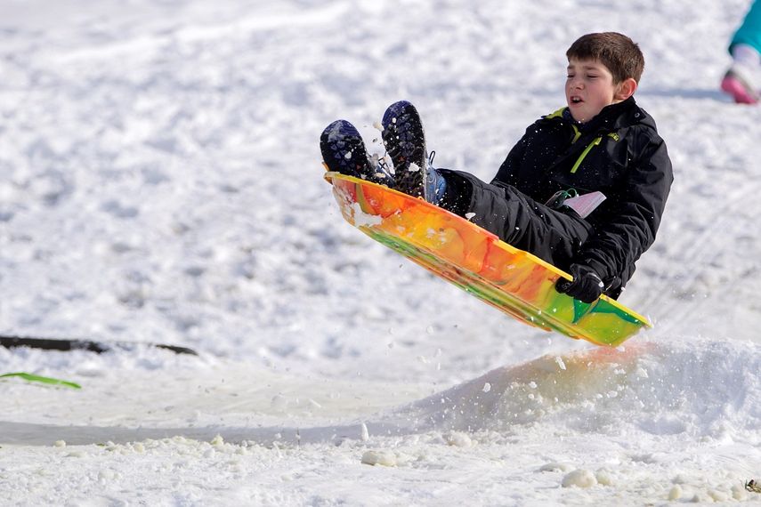 &nbsp;Un niño se desliza en trineo por una pendiente cubierta de nieve.