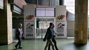 La gente pasa por el centro de información del Consejo Nacional Electoral (CNE) en Caracas el 16 de julio de 2024. Venezuela celebrará elecciones presidenciales el 28 de julio.