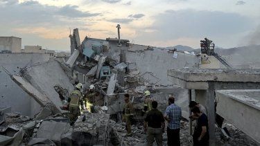 Personas y personal de emergencia se congregan en la azotea de un edificio que fue alcanzado por un ataque israelí en Teherán el 13 de junio de 2025.&nbsp;