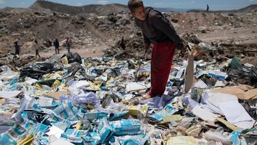 Ronaikel Brito, de 16 años, hurga en cartones de leche vacíos en el basurero de Pavia en las afueras de Barquisimeto, Venezuela, el miércoles 3 de marzo de 2021.&nbsp;