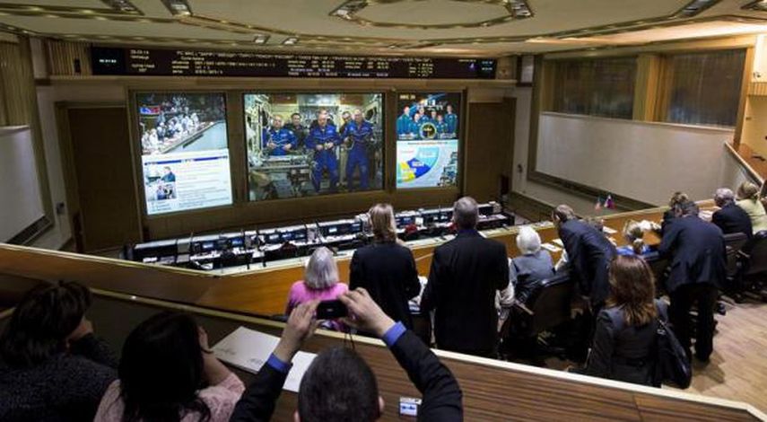 Fotografía cedida por la NASA que muestra a la tripulación de la nave Soyuz (en la pantalla gigante) durante una conexión en directo con el Centro de Control de Misiones ruso realizada tras alcanzar con éxito la Estación Espacial Internacional (EEI). E