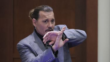 El actor Johnny Depp demuestra cómo afirma que se protegió de un presunto ataque de su ex esposa Amber Heard mientras testifica durante su juicio por difamación contra Heard, en el juzgado de circuito del condado de Fairfax en Fairfax, Virginia, el 20 de abril de 2022.&nbsp;