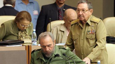 El dictador cubano Fidel Castro (izq.) es asistido por su hermano Raúl Castro, ministro de las Fuerzas Armadas, para tomar asiento el 23 de diciembre de 2004 en La Habana.&nbsp;