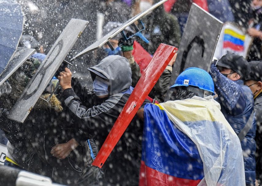 Manifestantes chocan con la policía antidisturbios durante una protesta contra el gobierno del presidente Iván Duque en la plaza Bolívar de Bogotá el 5 de mayo de 2021. Miles de personas regresaron a las calles de Colombia el miércoles en rechazo al gobierno de Iván Duque, quien ha cumplido una semana de presión con manifestaciones que se tornaron violentas en algunas ciudades y dejaron una veintena de muertos.