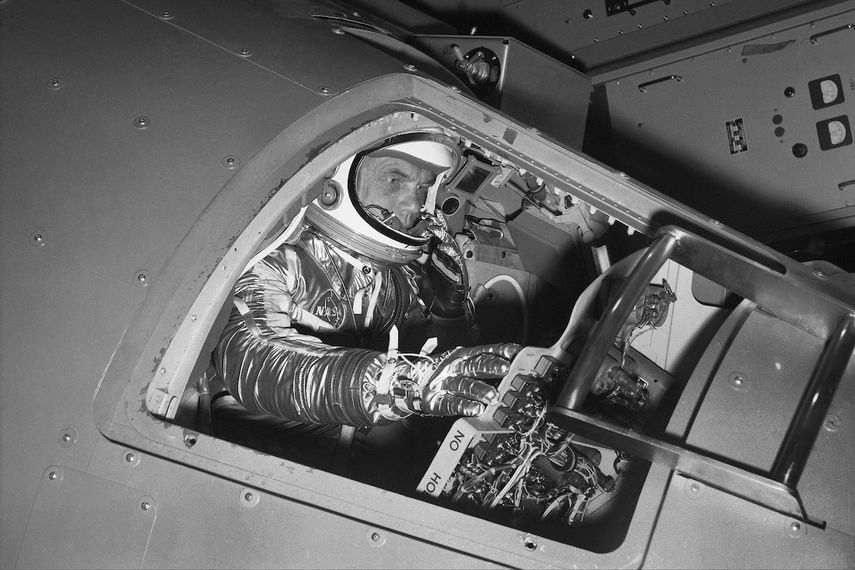 En esta foto de archivo del 11 de enero de 1961, el astronauta John Glenn maneja los controles en una cápsula Mercury para demostrar cómo el 1er astronauta estadounidense recorrerá el espacio, en el centro de investigaciones de la NASA en Langley Field, Virginia.&nbsp;