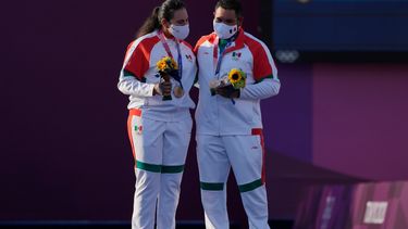 Los mexicanos Alejandra Valencia (izquierda) y Luis Álvarez celebran en el podio tras conseguir una medalla de bronce en la prueba mixta del tiro con arco de los Juegos Olímpicos de Tokio