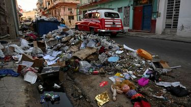 Un viejo coche americano pasa cerca de una gran cantidad de basura en una calle de La Habana el 21 de agosto de 2024.