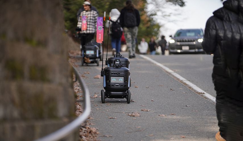Un robot repartidor transita por una acera.
