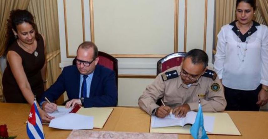 William Pérez González, vicejefe de la Aduana de Cuba, y Bob Van Den Bergher, representante de la ONUDD, firman un memorando para la inspección de contenedores.