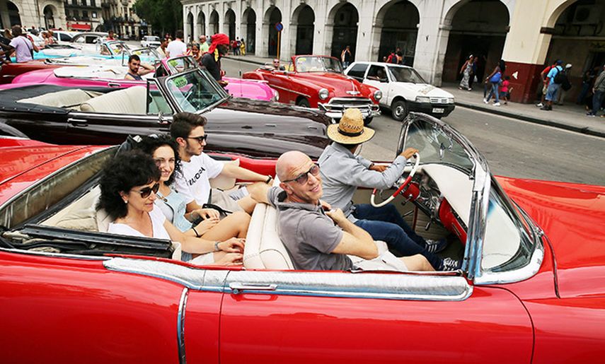 Un grupo de turistas viajan en un viejo descapotable del pasado siglo en La Habana. (EFE)