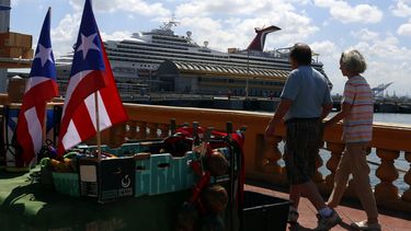 Dos turistas pasean frente a un crucero en el Puerto de San Juan, Puerto Rico. 