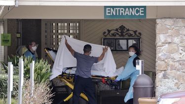 Una persona es trasladada en camilla hacia una ambulancia desde un hogar para adultos mayores en el que más de 50 personas enfermaron y esperan ser sometidas a pruebas por el COVID-19, el sábado 29 de febrero de 2020, en Kirkland, Washington. 