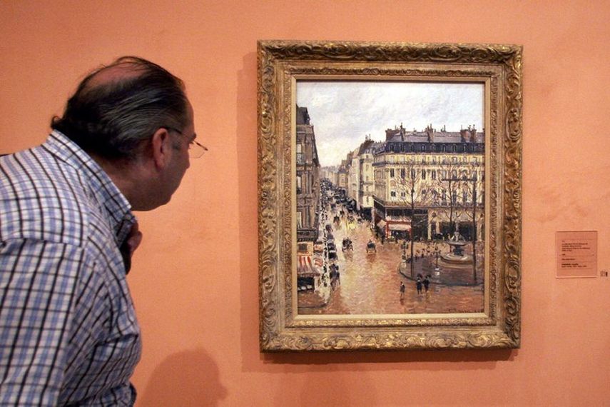 En esta imagen de archivo, tomada el 12 de mayo de 2005, un visitante observa el cuadro impresionista Rue St.-Honore, Apres-Midi, Effet de Pluie pintado en 1897 por Camille Pissarro, expuesto en el Museo Thyssen-Bornemisza, en Madrid.&nbsp;