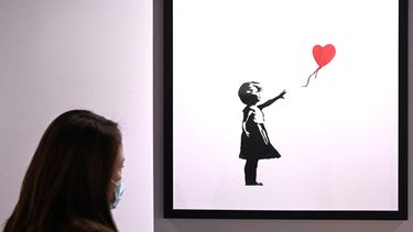 La gente ve el arte de Banksy -un artista callejero, activista político y director de cine radicado en Inglaterra- el día de la inauguración de la exposición El arte de Banksy sin límites, en Melbourne, el 21 de junio de 2024.