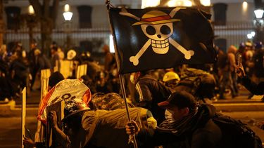 Manifestantes con una bandera del manga One Piece se enfrentan a agentes de la policía antidisturbios durante una protesta contra el presidente interino de Perú, José Jeri, en Lima el 15 de octubre de 2025. 