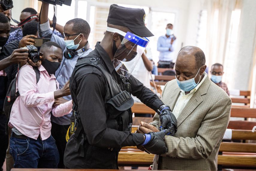 En esta foto de archivo tomada el 14 de septiembre de 2020, el héroe del Hotel Rwanda, Paul Rusesabagina (derecha), es esposado por un oficial de policía después de su sesión de la corte preliminar en el tribunal primario de Kicukiro en Kigali, Ruanda. Paul Rusesabagina, el héroe del Hotel Rwanda que se convirtió en un feroz crítico del gobierno, fue declarado culpable el 20 de septiembre de 2021 por cargos de terrorismo después de lo que sus partidarios dicen que fue un juicio por motivos políticos. &nbsp;