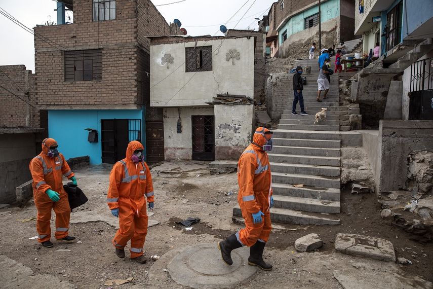 Los trabajadores de la funeraria Piedrangel Alexander Carballo (izquierda) y Luis Brito (derecha). ambos venezolanos, y el peruano Mart&iacute;n &Aacute;guila, llegan al vecindario de El Augustino para retirar el cuerpo de un residente que se sospecha que muri&oacute; por coronavirus, en Lima, Per&uacute;, el 4 de mayo de 2020. La labor de recopilar los cad&aacute;veres de supuestas v&iacute;ctimas del virus ha reca&iacute;do en los trabajadores de la funeraria Piedrangel, que llegan a hacerse cargo de hasta 10 cuerpos al d&iacute;a. (AP/Rodrigo Abd