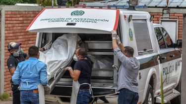 Miembros de la fuerza policial descargan los cuerpos de las víctimas de una masacre presuntamente a manos de grupos armados en el municipio colombiano de Arauca, cerca de la frontera con Venezuela.