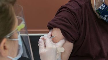 Una enfermera administra vacuna a un paciente.
