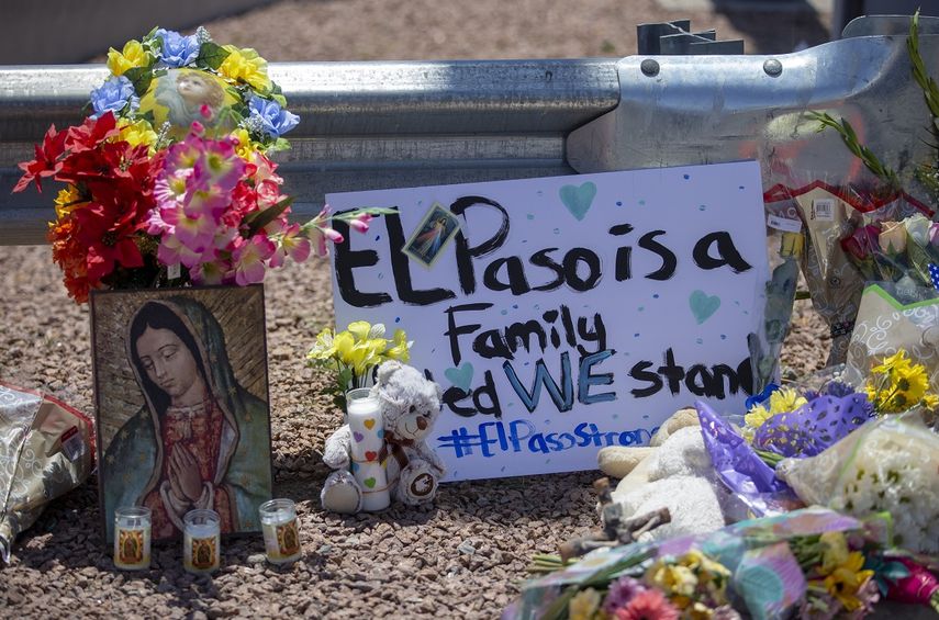 Unas flores y una imagen de la Virgen de Guadalupe adornan un monumento conmemorativo improvisado en honor de las víctimas de un tiroteo en un centro comercial en El Paso, Texas, el domingo 4 de agosto de 2019. El letrero dice: El Paso es una familia. Permanecemos unidos.