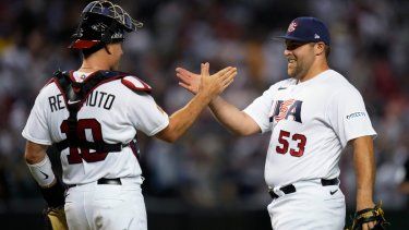 David Bednar (derecha) festeja con J.T. Realmuto luego de que Estados Unidos venciera a Gran Bretaña en el Clásico Mundial, el sábado 11 de marzo de 2023, en Phoenix.