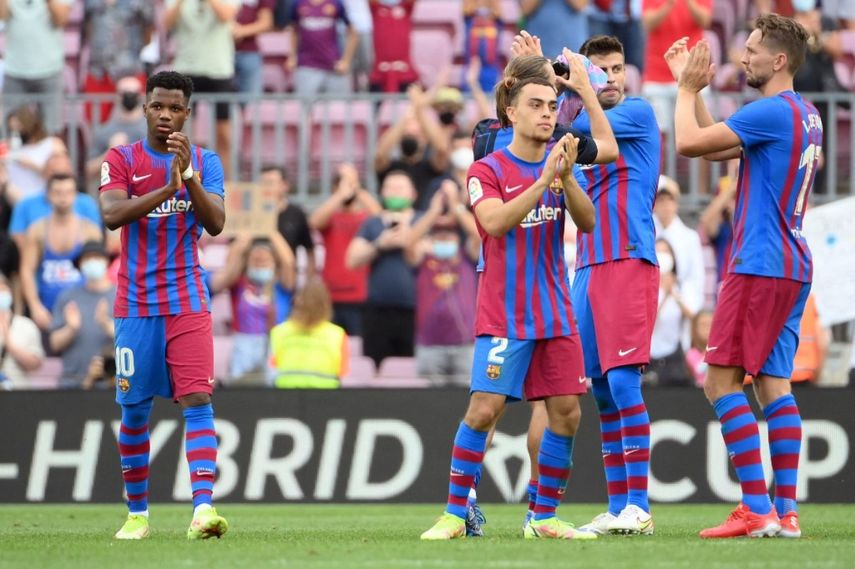El centrocampista español del Barcelona Ansu Fati (izq.) Y sus compañeros celebran su victoria al final del partido de fútbol de la Liga española entre el FC Barcelona y el Levante UD en el estadio Camp Nou de Barcelona el 26 de septiembre.
