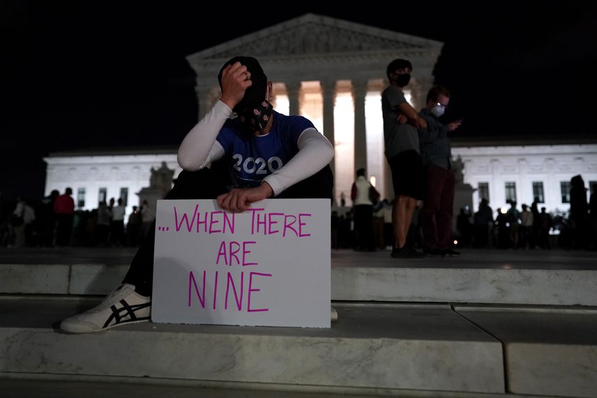 Una mujer sostiene un cartel y gesticula mientras la gente se re&uacute;ne en un memorial improvisado para la difunta jueza Ruth Bader Ginsburg en los escalones del edificio de la Corte Suprema, en Washington, DC, el 18 de septiembre de 2020.&nbsp;
