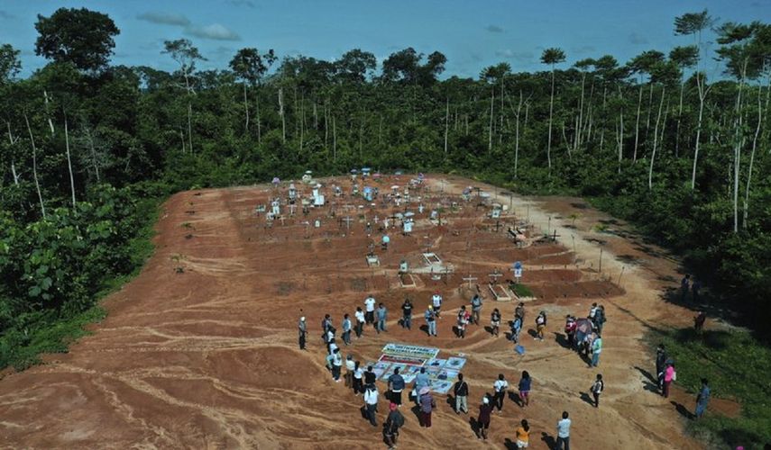 Familiares de personas que murieron por COVID-19 se reúnen junto a una fosa común clandestina en las afueras de Iquitos, Perú, el sábado 20 de marzo de 2021. Las autoridades locales aprobaron entierros masivos de víctimas de la pandemia, pero nunca se lo dijeron a las familias que creían que sus seres queridos estaban enterrados en el cementerio local cercano y solo meses después descubrieron la verdad.&nbsp;