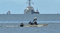 Una lancha rápida de la Guardia Costera de Trinidad y Tobago patrulla mientras el buque de guerra USS Gravely es visto a la distancia desde Puerto España el 26 de octubre de 2025.&nbsp;