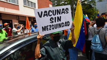 Un activista sostiene un cartel que dice “Vacunas sin mezquindad” durante una protesta de venezolanos para exigir que todos los trabajadores de la salud sean vacunados contra el COVID-19, en la plaza Los Palos Grandes, en Caracas el 17 de abril de 2021. &nbsp;