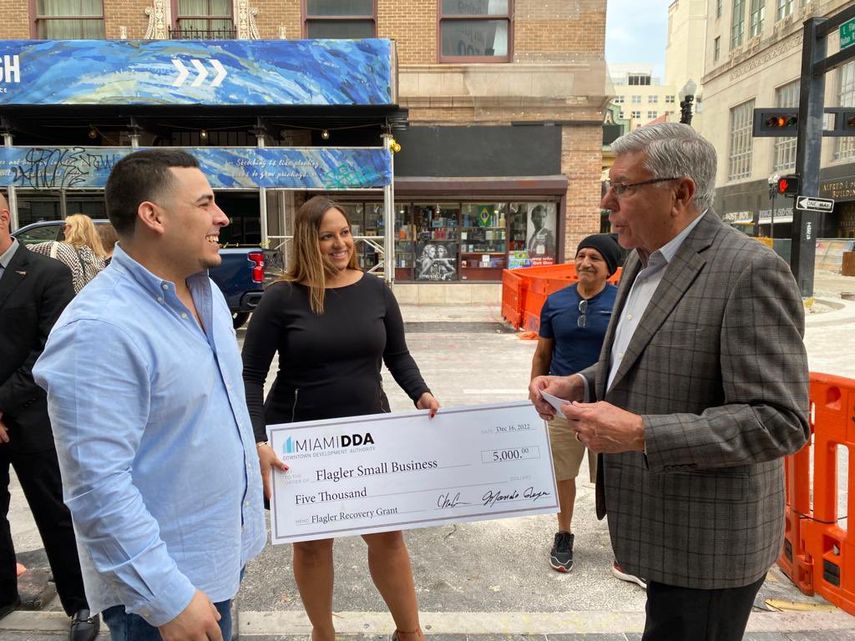 Manolo Reyes, comisionado del distrito 4 de la ciudad de Miami, entrega un cheque por valor de 5.000 dólares a pequeño comerciante.&nbsp;